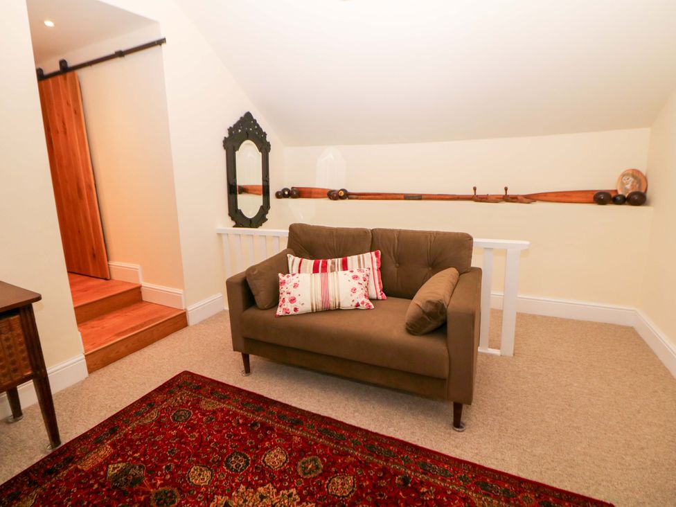 A snug with a sofa and mirror at Laneside Barn in Calver