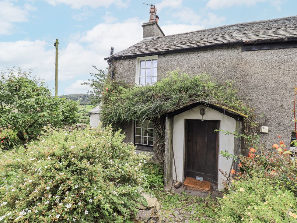 A cottage entrance surrounded by plants and a path at Old Cottage in Oxen Park near Ulverston
