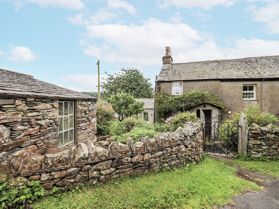 An outdoor area with a cottage and garden at The Old Cottage in Oxen Park near Ulverston
