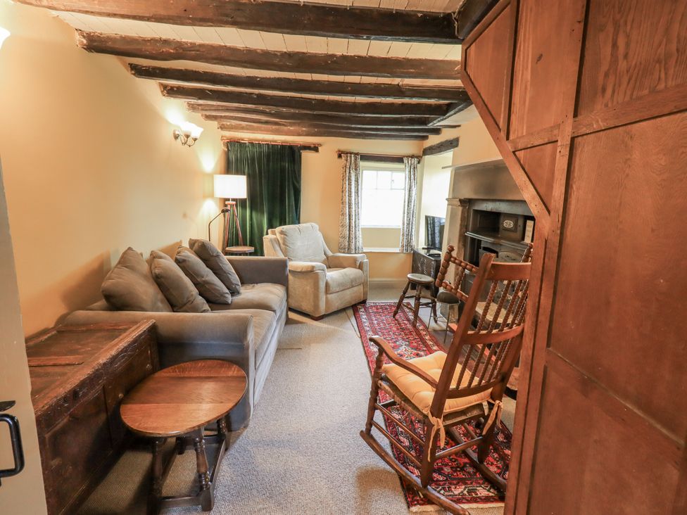 A living room with a sofa and rocking chair at Old Cottage in Oxen Park near Ulverston