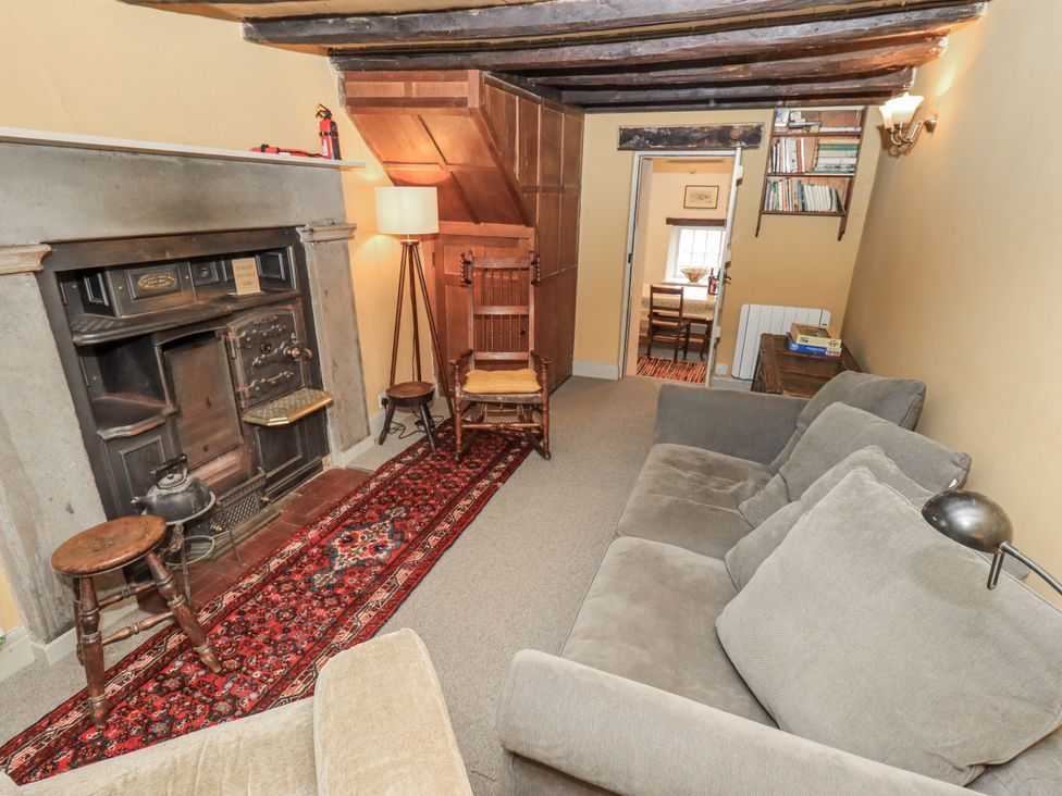 A living room with a fireplace and seating area at Old Cottage in Oxen Park near Ulverston
