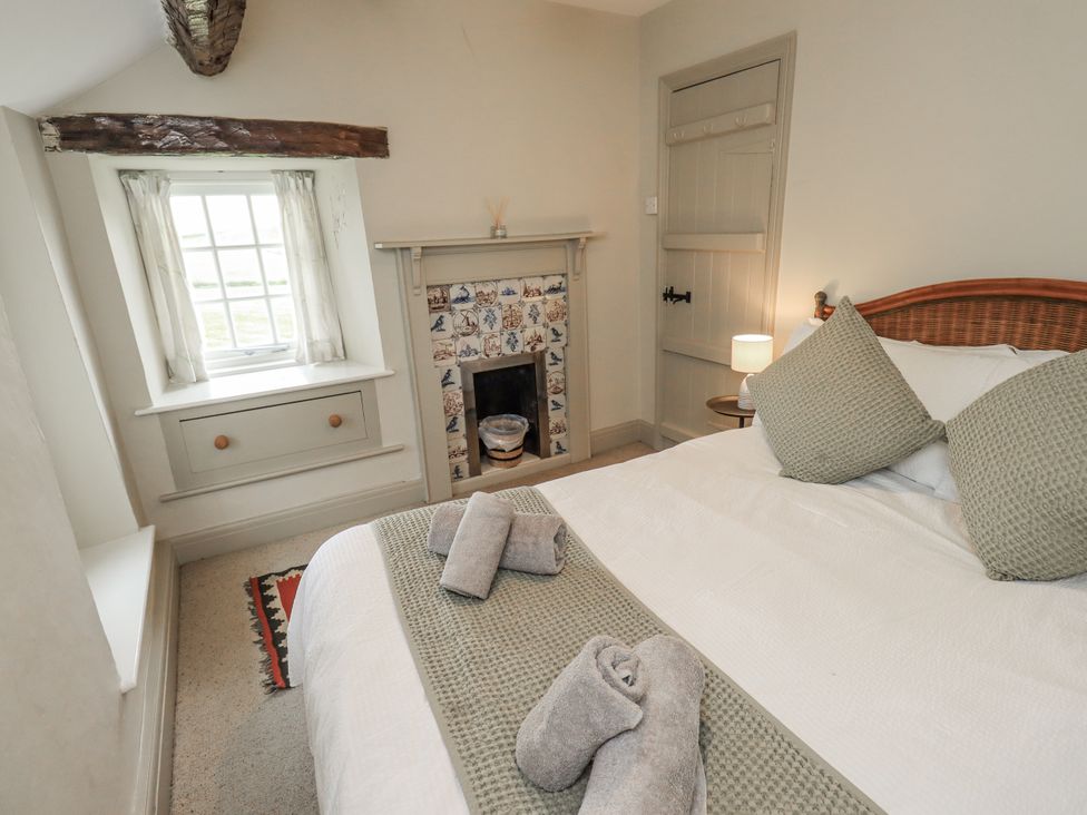 A bedroom with a bed and towels on the bed at Old Cottage in Oxen Park near Ulverston