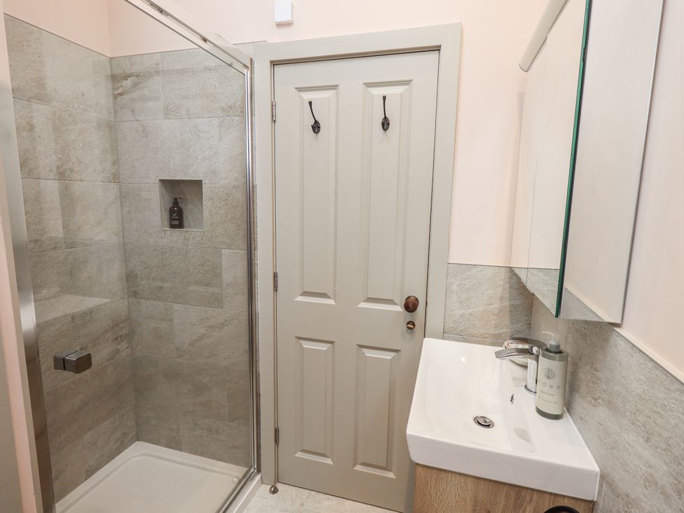 A bathroom with a shower and sink at Old Cottage in Oxen Park near Ulverston