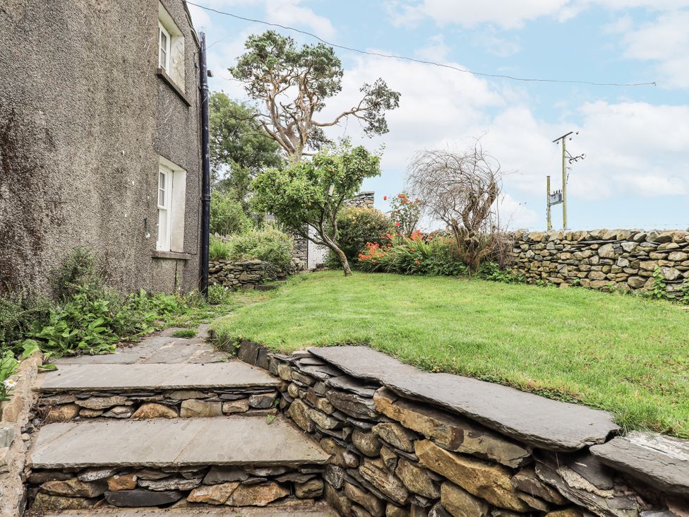 A garden with stone steps and a tree at Old Cottage in Oxen Park near Ulverston