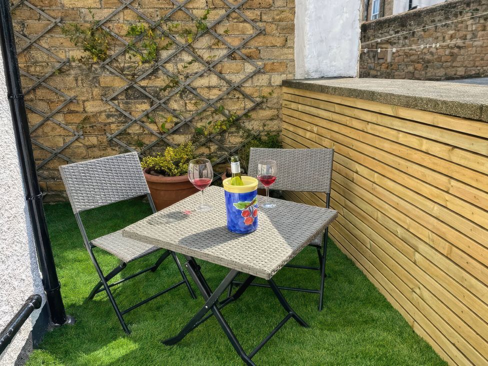An outdoor seating area with a table, chairs, and drinks at Number Ten in Amble