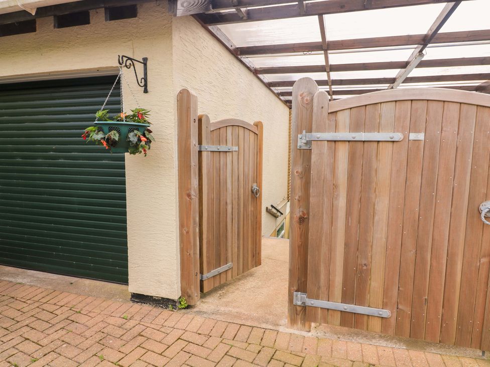 An outdoor area with wooden gates and a garage door at Garden View in Hillhead near Brixham