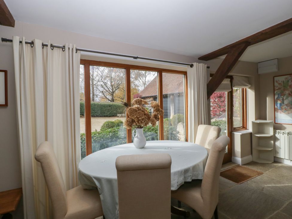 A dining room with a round table and chairs at Stable Cottage in Broadway