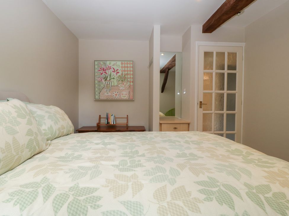 A bedroom with a bed and bedside table at Stable Cottage in Broadway
