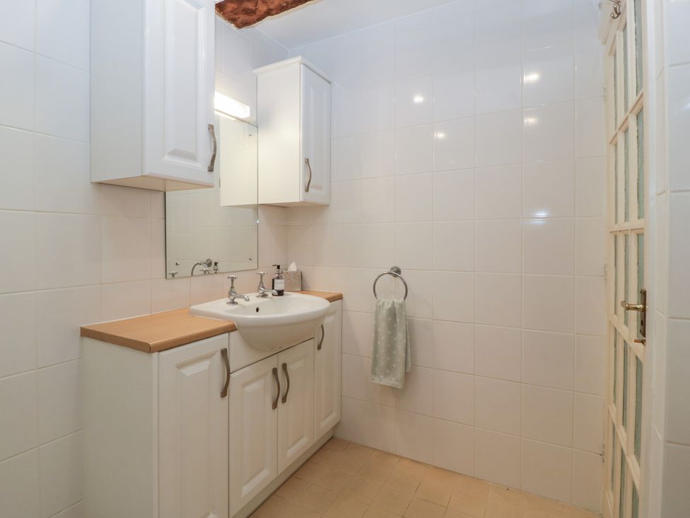 A bathroom with a sink and cabinet at Stable Cottage in Broadway