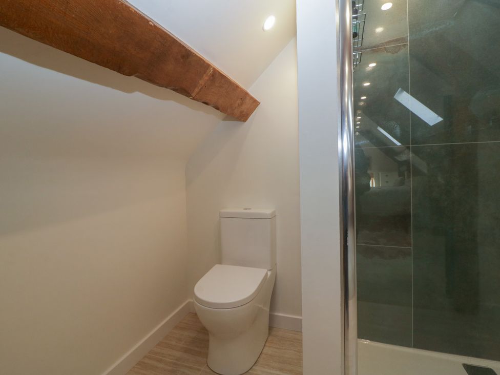 A bathroom with a toilet and shower at Stable Cottage Broadway