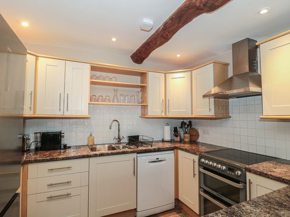 A kitchen with cabinets and a sink at Stable Cottage in Saintbury near Broadway