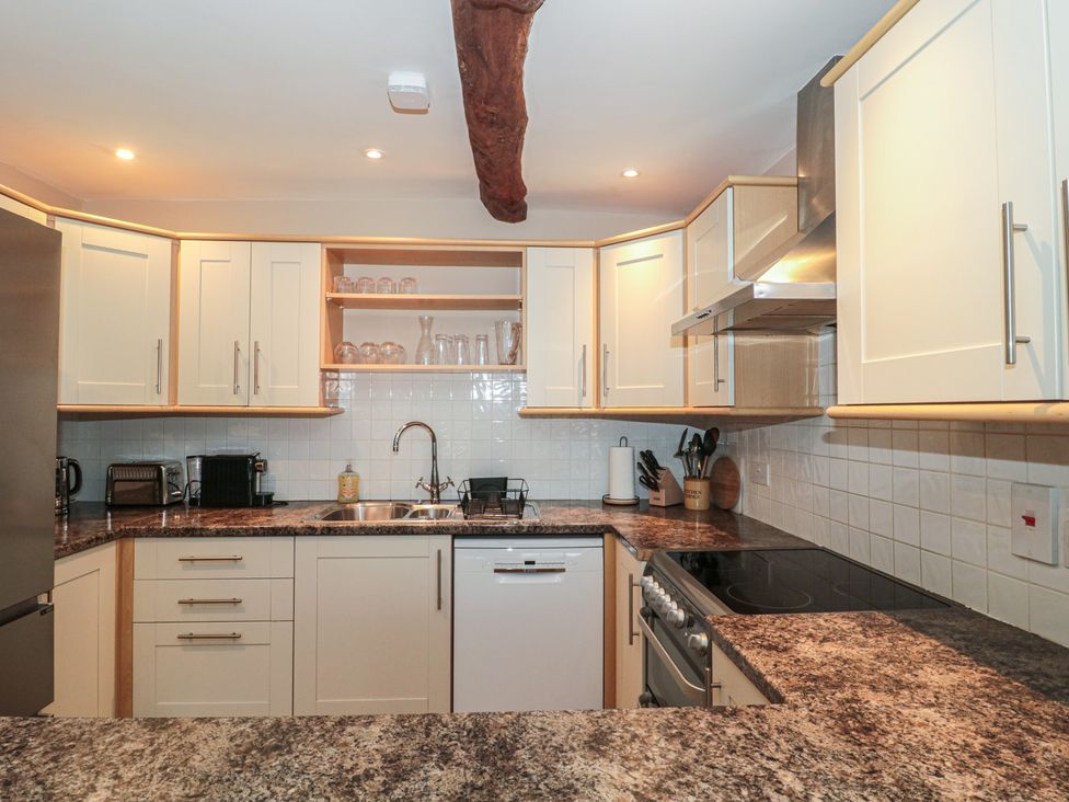 A kitchen with cabinets, sink, and appliances at Stable Cottage in Saintbury near Broadway
