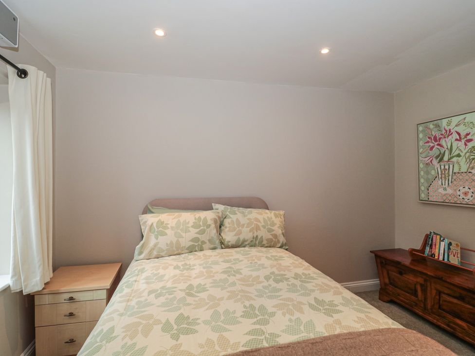 A bedroom with a bed and curtains at Stable Cottage in Saintbury near Broadway