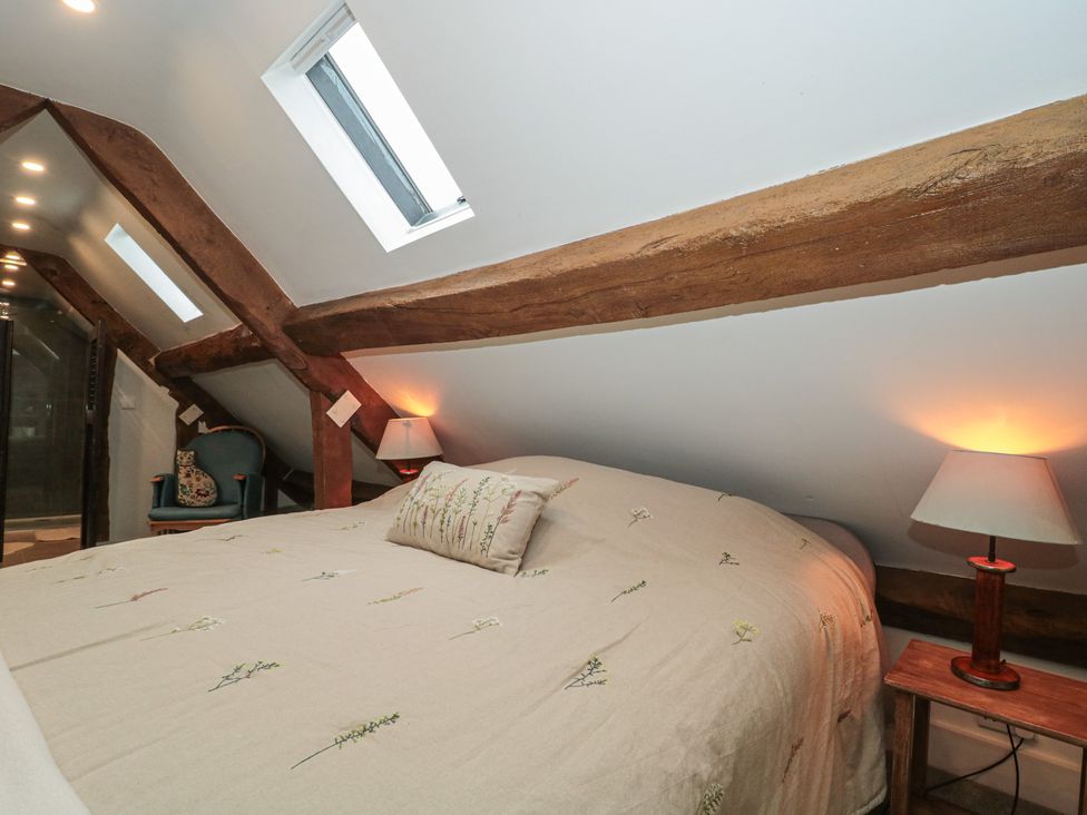A bedroom with a bed and bedside lamps at Stable Cottage in Saintbury near Broadway
