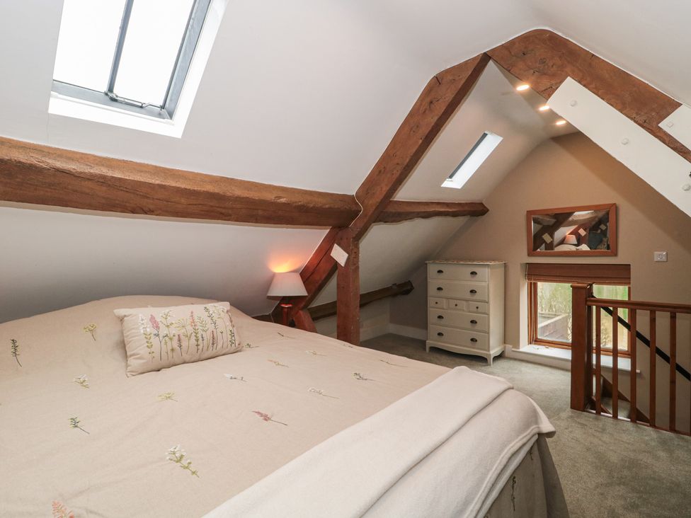 A bedroom with a bed and a dresser at Stable Cottage in Saintbury near Broadway