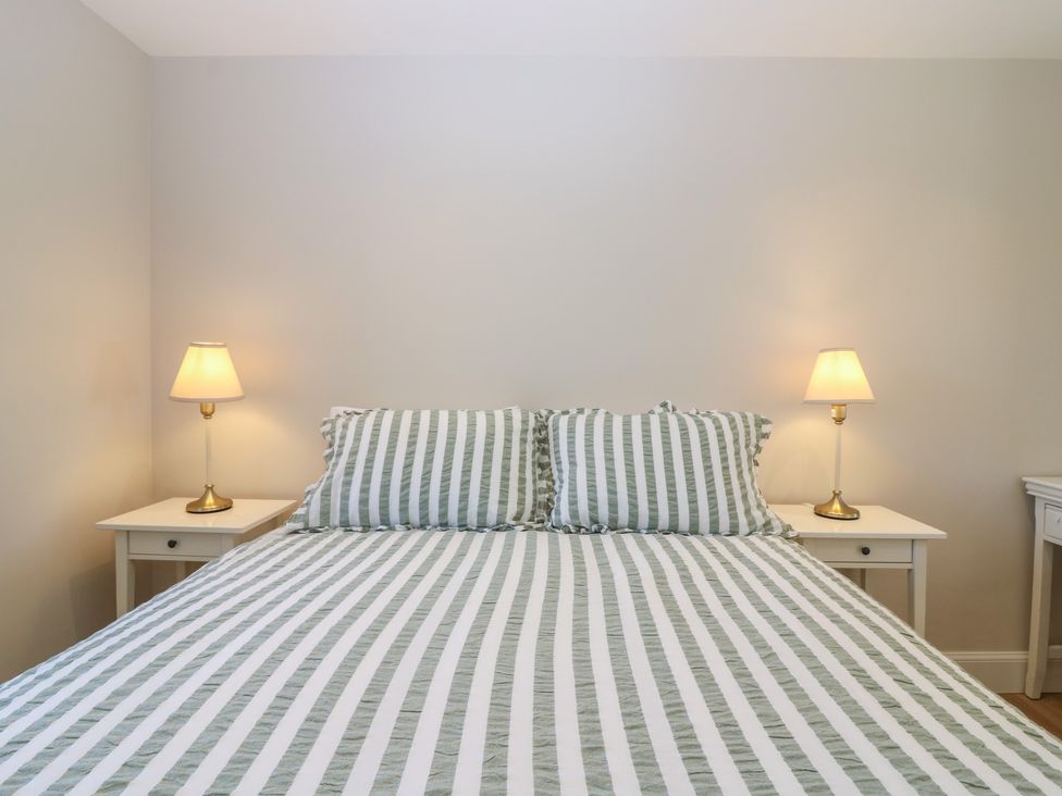 A bedroom with a bed and lamps on side tables at No 4 - 3 bed Haddington