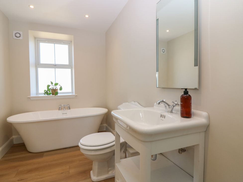 A bathroom with a bathtub, toilet, and sink at No 4 - 3 bed Haddington