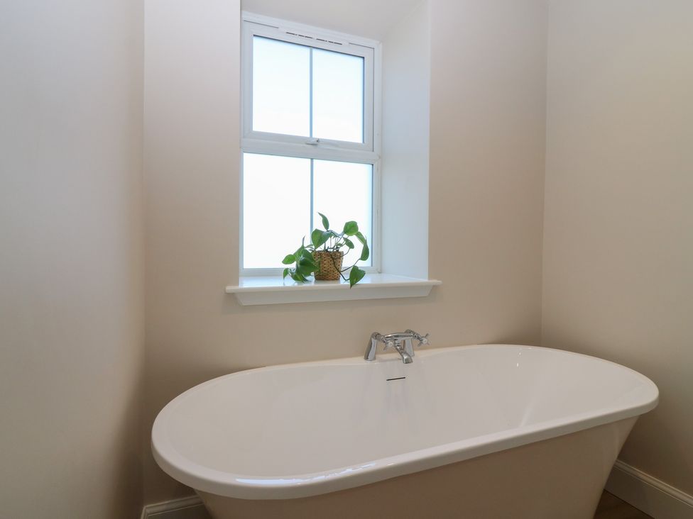 A bathroom featuring a bathtub and a window at No 4 - 3 bed in Haddington
