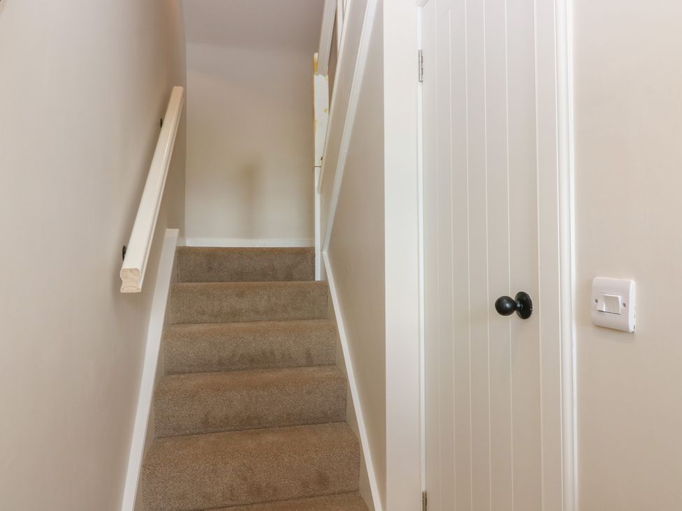 A staircase with a handrail and a door at No 4 - 3 bed Haddington