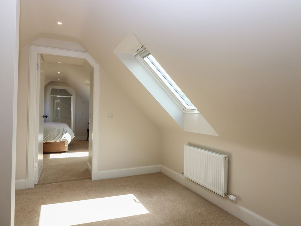 A bedroom with a skylight and door leading to another room at No 4 - 3 bed Haddington