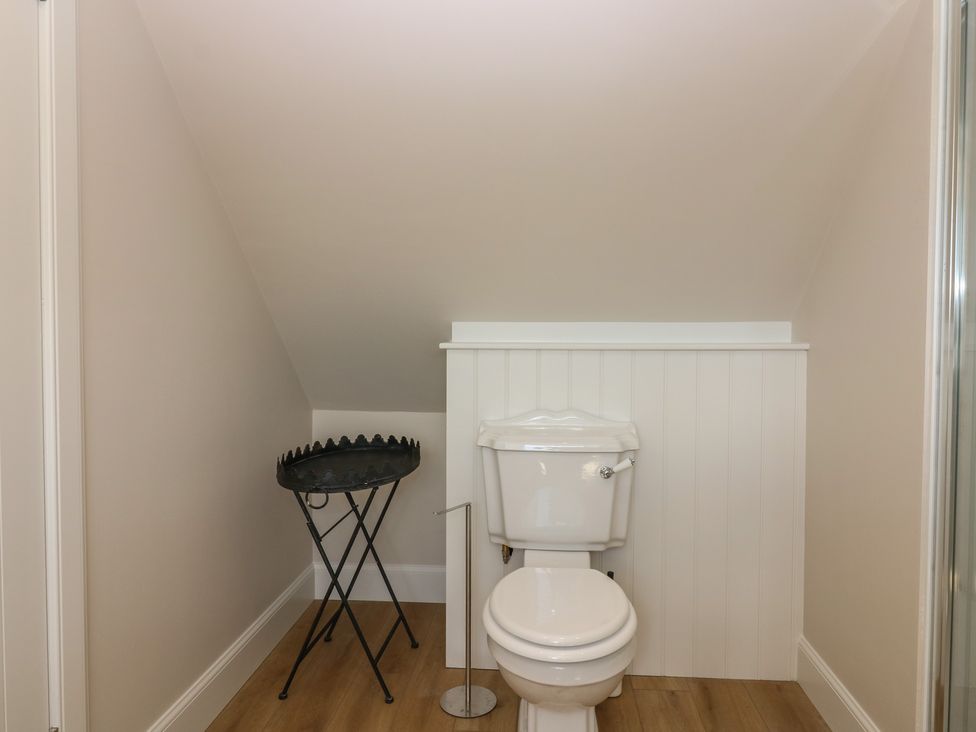 A bathroom with toilet and round table at No 4 - 3 bed Haddington