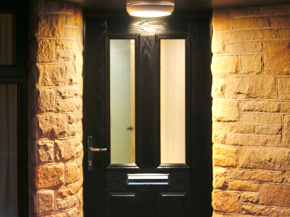 An entrance with a black door and stone wall at Havendale in Chesterfield
