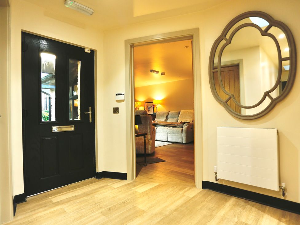 A hallway leading to a living room with a front door at Havendale Chesterfield