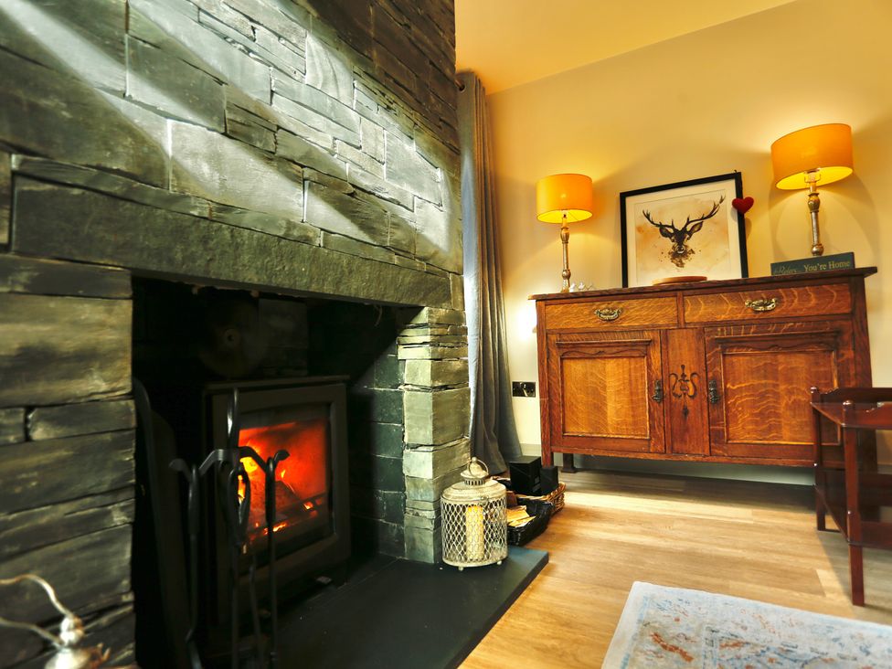 A living room with a fireplace and wooden cabinet at Havendale Chesterfield