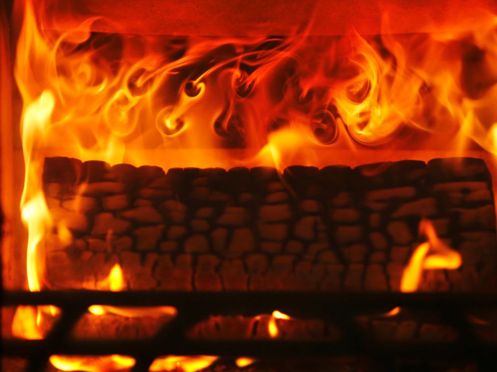 A fireplace with burning logs at Havendale in Chesterfield
