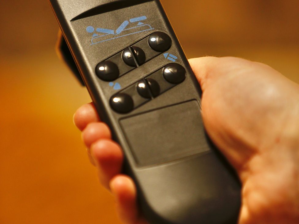 A remote control with buttons in a hand at Havendale Chesterfield