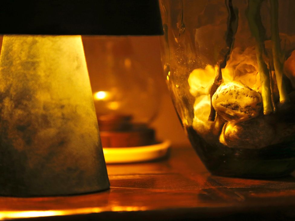 A lamp and decorative vase with pebbles in a living room at Havendale Chesterfield