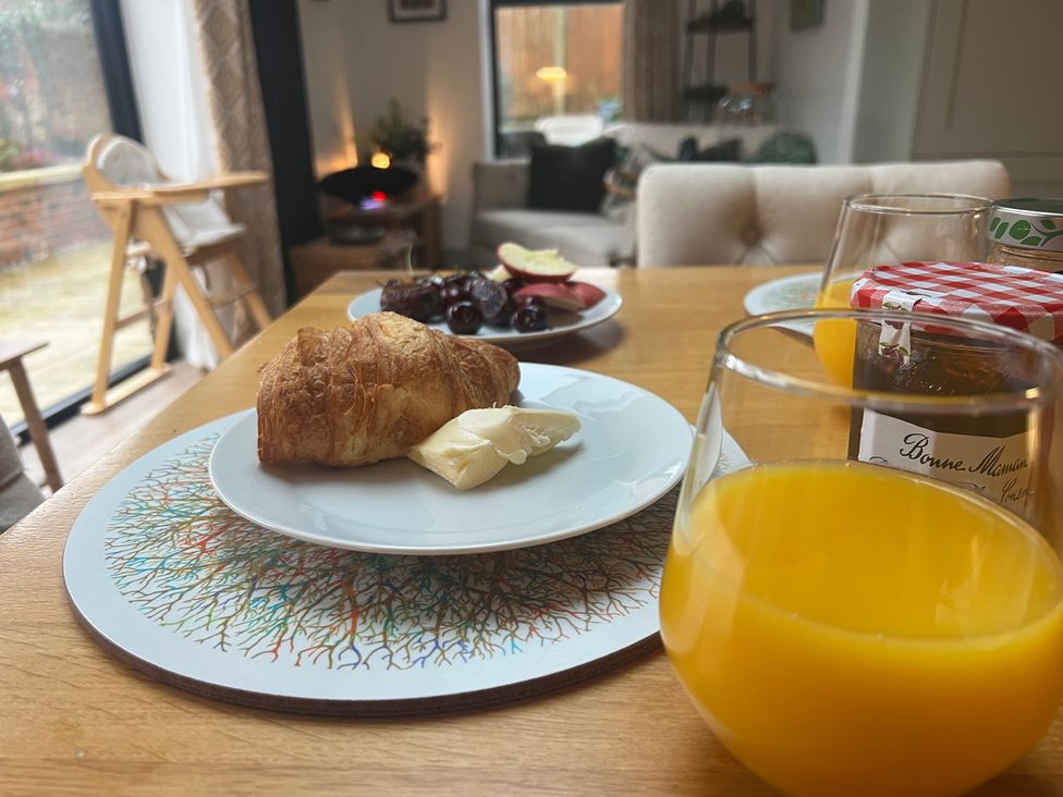 A dining room table with a croissant and orange juice at Havendale Chesterfield