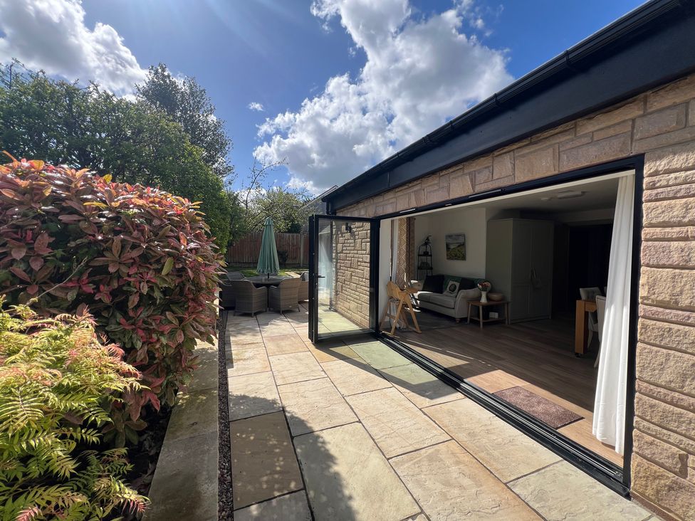 A patio with garden furniture overlooking a living room at Havendale in Chesterfield