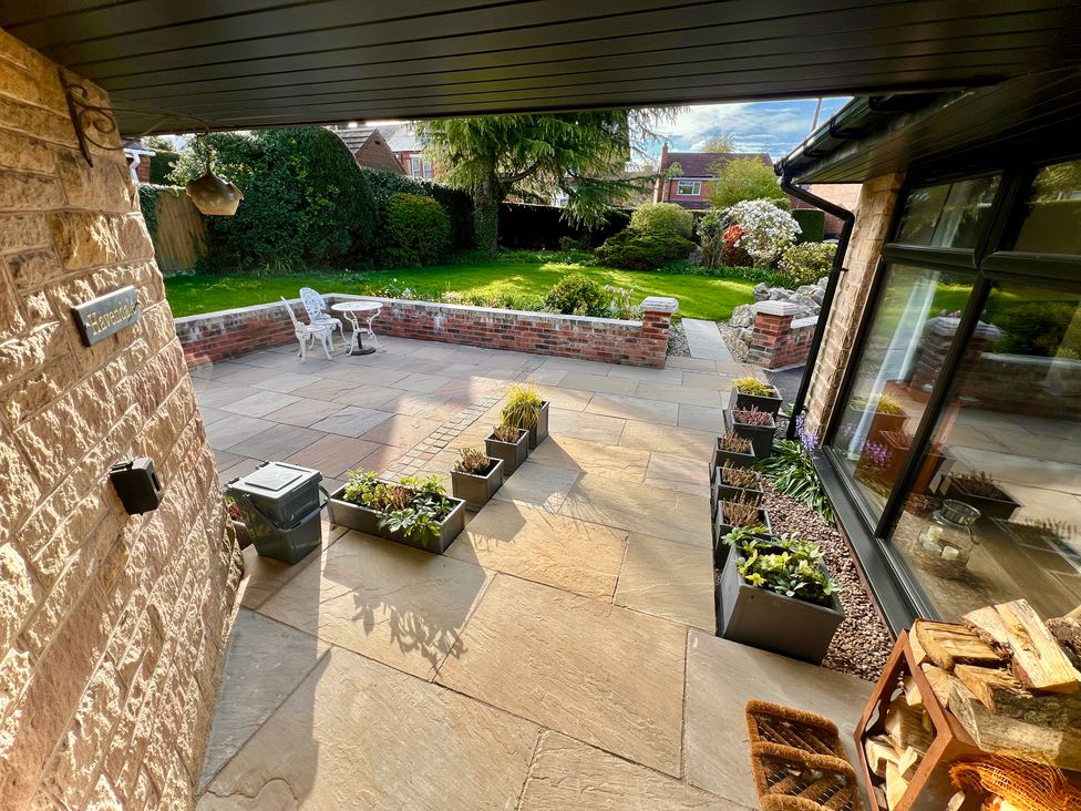 A garden with a patio and chairs at Havendale in Chesterfield