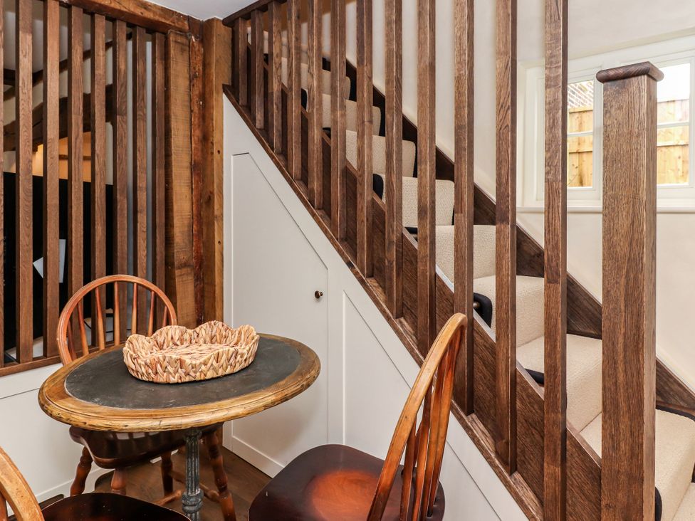 A table and chairs near stairs at Tuffs Farm Cottage 1 Kings Langley