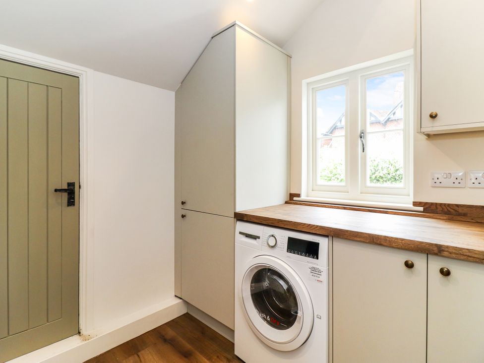 A laundry room with a washing machine and a window at Tuffs Farm Cottage 1 Kings Langley