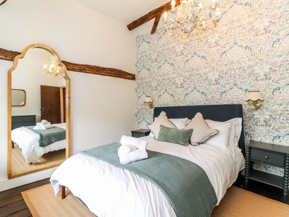 A bedroom with a bed and mirror at Tuffs Farm Cottage 1 Kings Langley