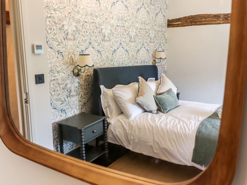A bedroom with a bed and bedside table at Tuffs Farm Cottage 1 Kings Langley