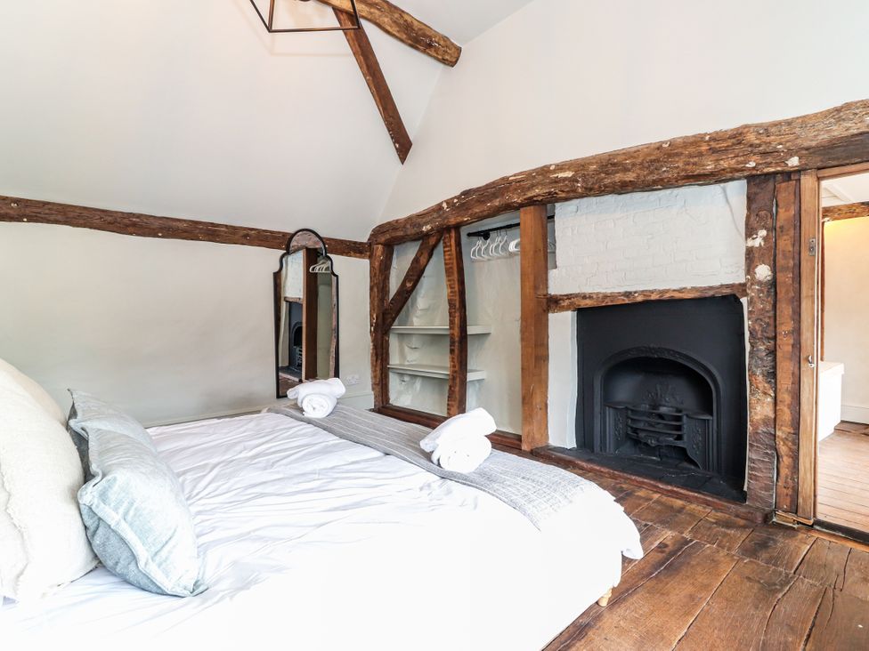 A bedroom with a bed and mirror at Tuffs Farm Cottage 1 in Kings Langley