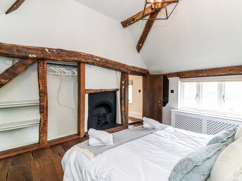 A bedroom with a bed and a fireplace at Tuffs Farm Cottage 1 in Kings Langley