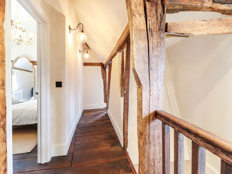 A hallway with wooden beams and light fixtures at Tuffs Farm Cottage 1 Kings Langley