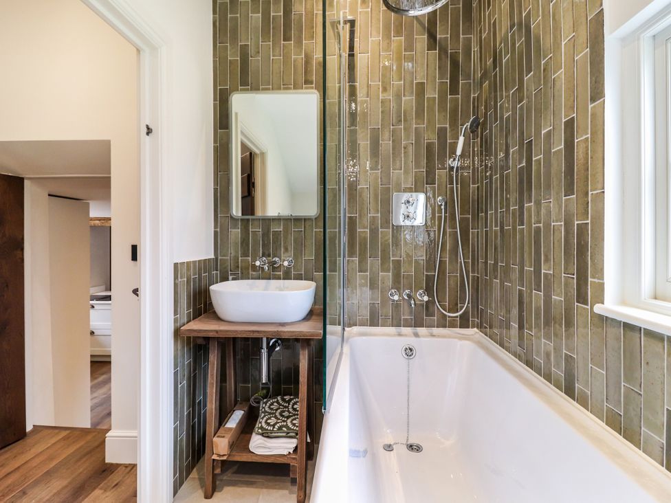 A bathroom with a bathtub, sink, and shower at Tuffs Farm Cottage 1 in Kings Langley