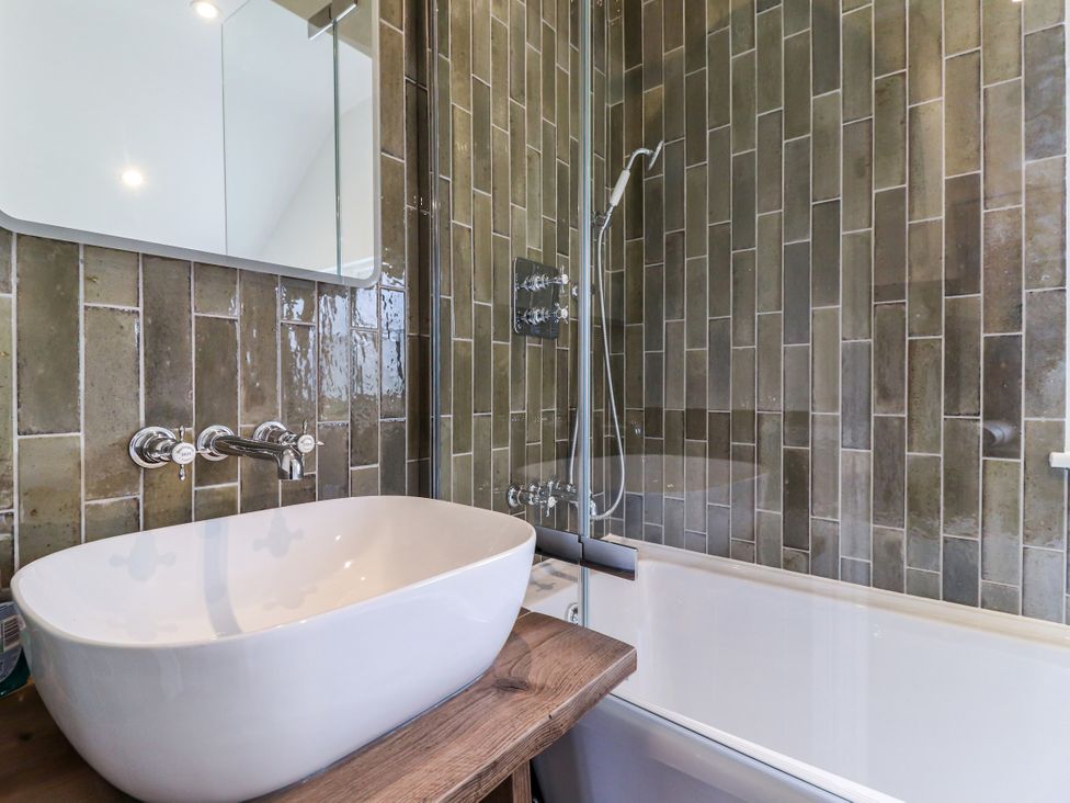 A bathroom with a bathtub and sink at Tuffs Farm Cottage 1 in Kings Langley