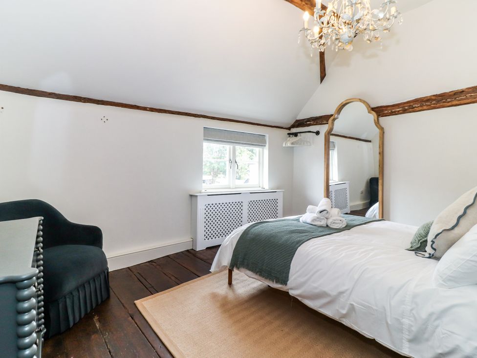 A bedroom with a bed and chair at Tuffs Farm Cottage 1 Kings Langley