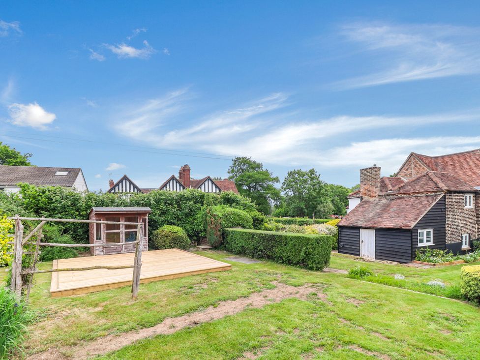 A garden with decking and a shed at Tuffs Farm Cottage 1 Kings Langley