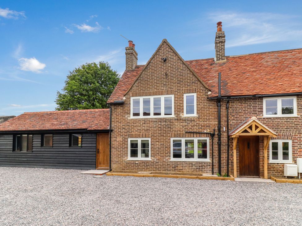 A house with multiple windows and a gravel driveway at Tuffs Farm Cottage 2 Kings Langley