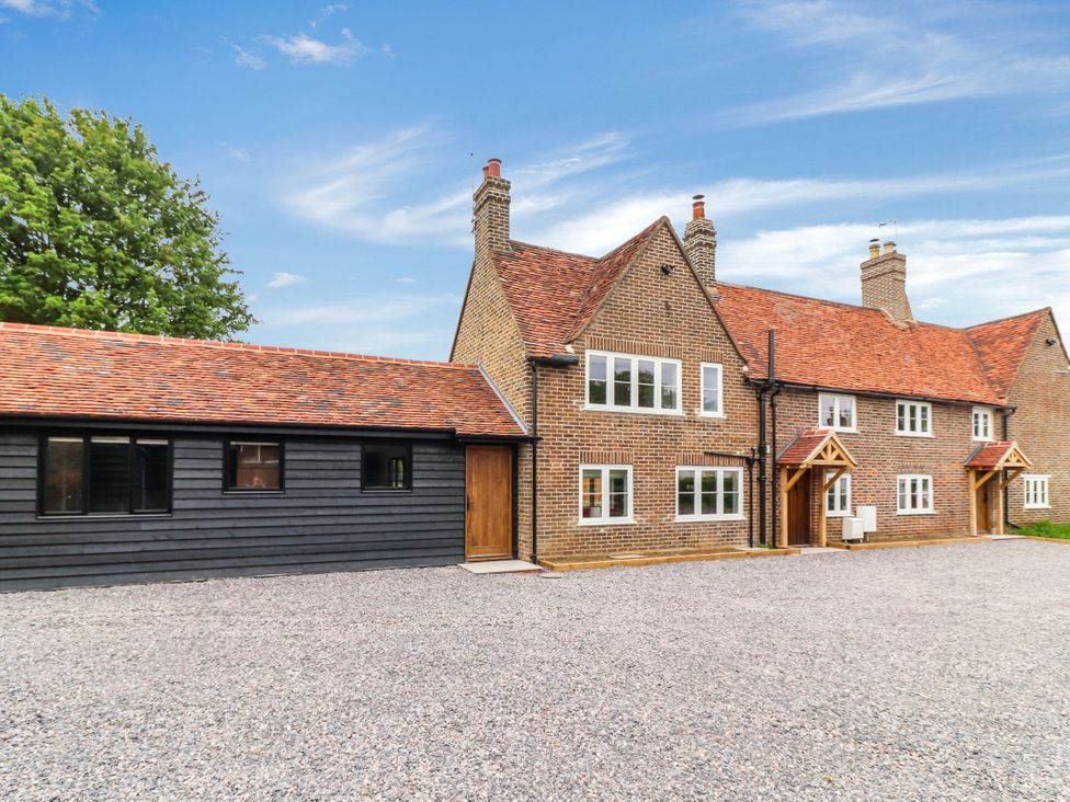 A house with a gravel driveway at Tuffs Farm Cottage 2 in Kings Langley