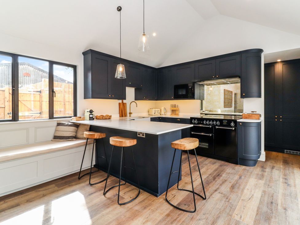 A kitchen with black cabinets and a central island at Tuffs Farm Cottage 2 in Kings Langley