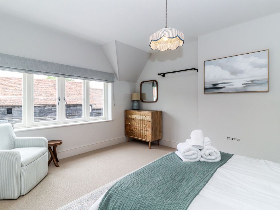 A bedroom with a bed and a chest of drawers at Tuffs Farm Cottage 2 Kings Langley
