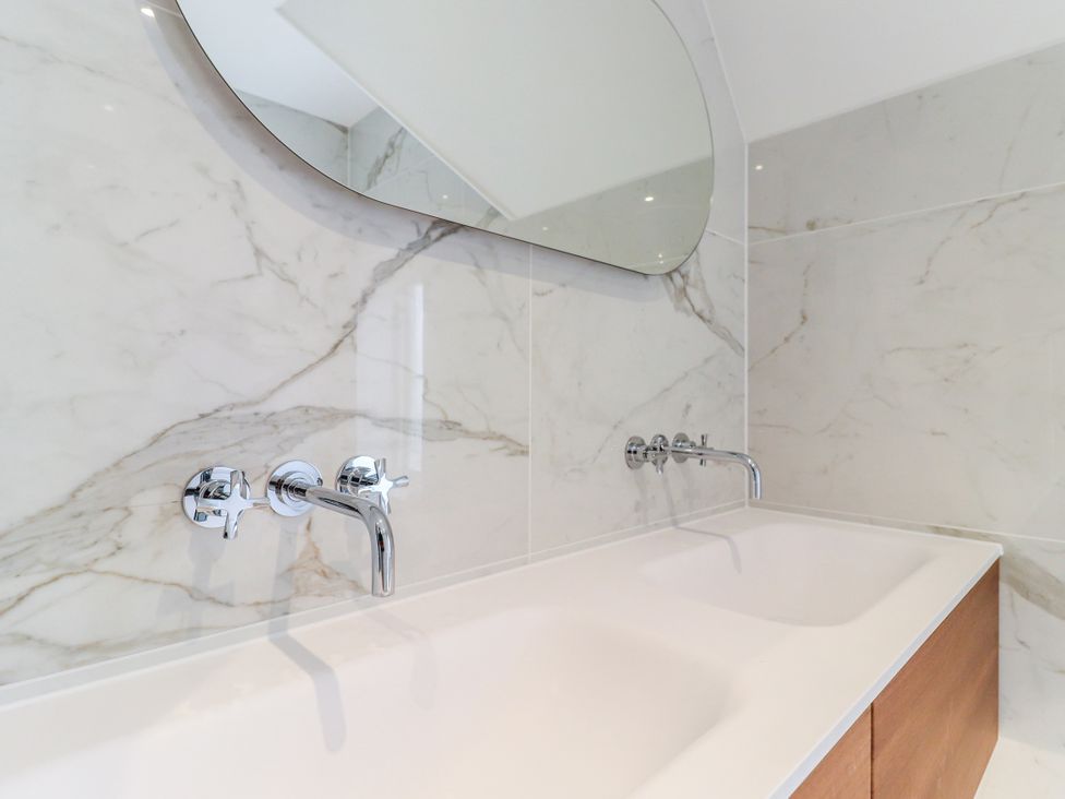 A bathroom with a bathtub and mirror at Tuffs Farm Cottage 2 in Kings Langley